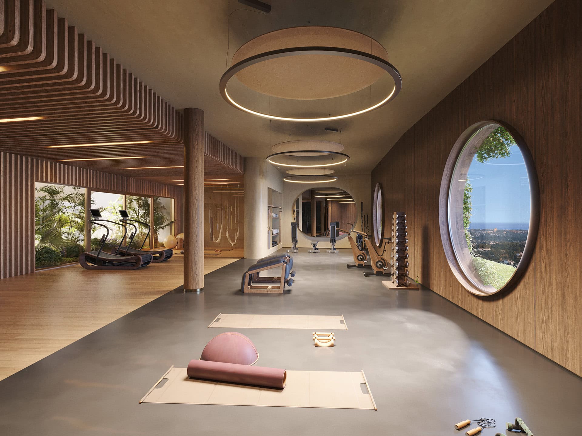 Nowoczesna siłownia w luksusowym domu z dużymi oknami i panoramicznym widokiem na zieleń. Wyposażona w sprzęt fitness, strefę jogi oraz designerskie elementy wnętrza. Idealne miejsce do aktywnego wypoczynku.